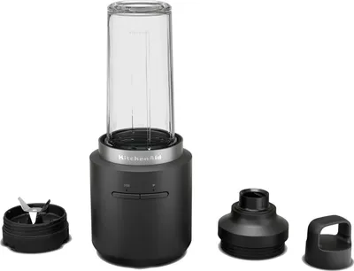 A black KitchenAid portable mini blender with its accessories laid out on a white background.
