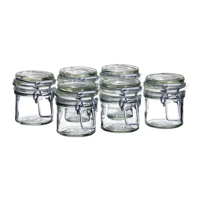 A group of six small glass jars with clamp lids are arranged in a row on a white background.