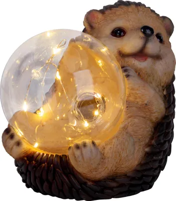A decorative LED solar light shaped like a hedgehog holding a clear sphere with lights inside.