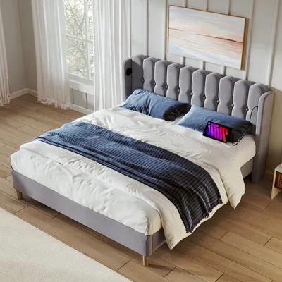 A bedroom scene with a bed, pillows, and a blanket.