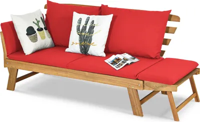 A wooden garden bench with red cushions and decorative pillows.