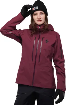 Dame trägt die "Recon Stretch LT Shell - Women"s" Jacke von Black Diamond in dunklem Rot; mit Kapuze und Handschuhen.
