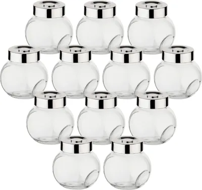 A set of small, clear glass jars with silver lids arranged in rows.