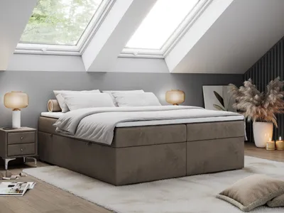 A bedroom scene with a bed, nightstands, and lamps, set in an attic room with skylights.