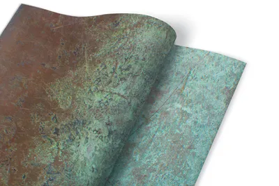Two sheets of oxidized copper foil are shown, with one slightly curled over the other.