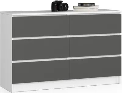 A white dresser with graphite gray drawers is displayed against a white background. A black camera and a stack of books are on top of the dresser.
