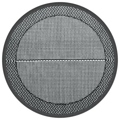 A round outdoor rug with a geometric pattern.