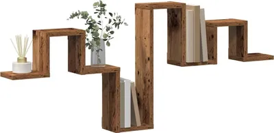 A wooden zig-zag wall shelf with books and a decorative item.