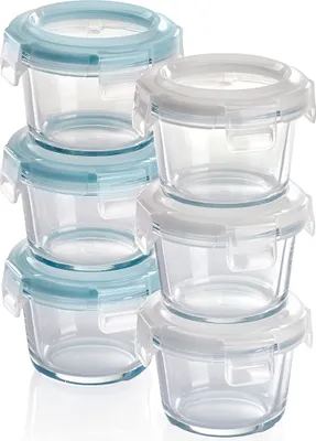 A stack of small glass food storage containers with blue and white lids.