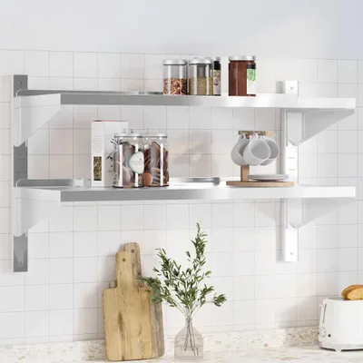 A kitchen counter with a tiled backsplash, featuring a two-tiered wall shelf holding various kitchen items.