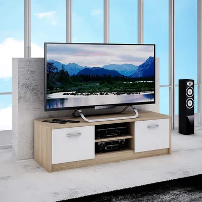 A television stand with a television on top, placed in a room with large windows.