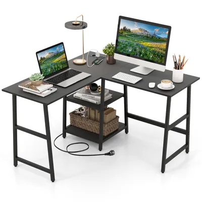 An L-shaped desk with a laptop, desktop computer, lamp, and accessories.