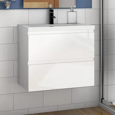 A white bathroom vanity with a black faucet against a tiled wall.