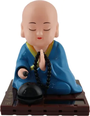 A solar-powered Wackelfigur (wobble figure) of a Buddha in blue robes, sitting in meditation with prayer beads.