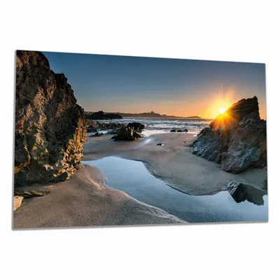 Produktbild von Wallario Herdabdeckplatte aus Glas, Größe 90 x 52 cm 1-teilig, Motiv Sonnenuntergang hinter einem Felsen am Strand