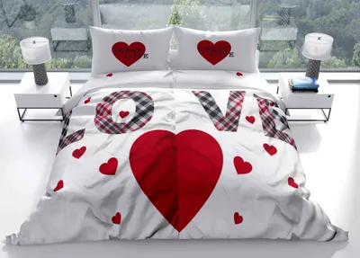 A bed with a "Love" themed duvet cover and pillows.