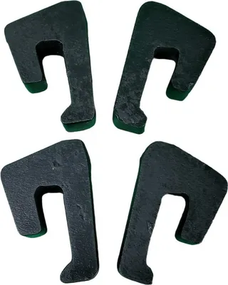 Four black rubber spacers with green bottoms are arranged in a square formation on a white background.