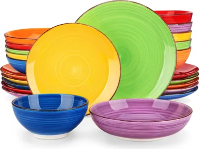 A collection of colorful ceramic plates and bowls stacked and arranged.