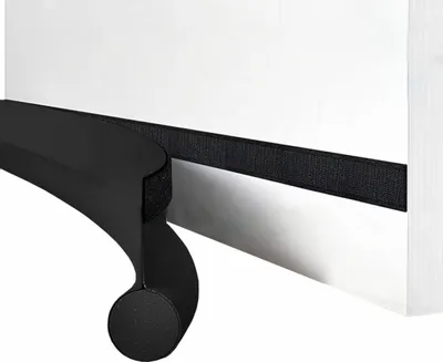 A close-up view of a black foam door seal with a velcro strip attached to a white surface.