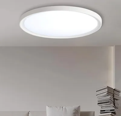 A white, circular LED ceiling light is mounted on a light gray ceiling.