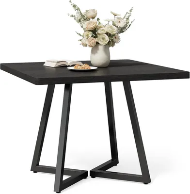 A square black table with a vase of flowers and a book on it, set against a white background.