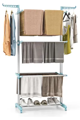 A three-tier drying rack with clothes and towels on it, and shoes on the bottom shelf.