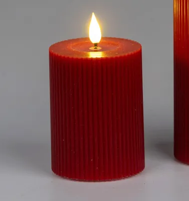A close-up of a red LED candle with a flame.