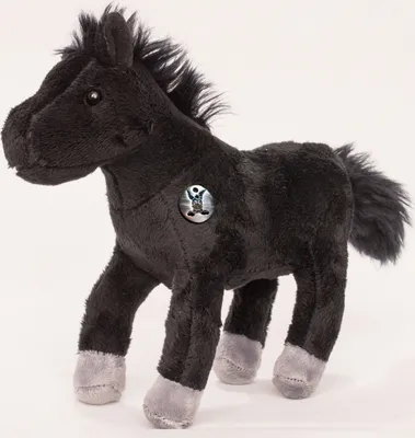 A black plush horse toy with gray hooves and a circular badge on its chest.