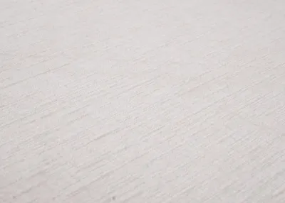 A close-up shot of a textured, light-colored fabric surface, likely a textile or upholstery.
