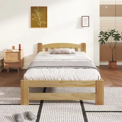 A bedroom with a wooden bed frame and bedding.