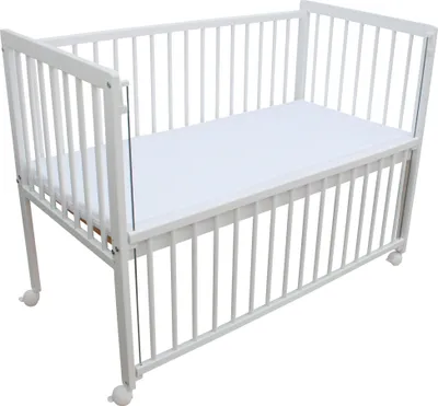 A white baby crib with a mattress inside, shown from a slightly elevated side angle against a white background.