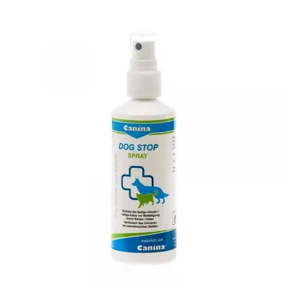 A white spray bottle with a blue and green label for dog repellent.