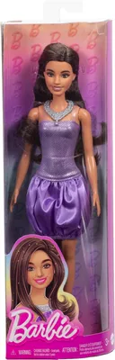 A Barbie doll in a purple sequin dress and satin skirt, displayed in its retail packaging.