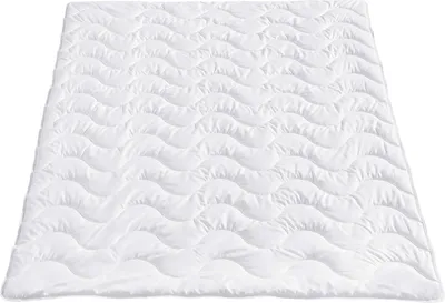 A white quilted blanket laid flat on a white background.