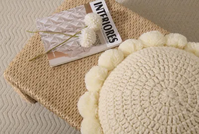 Zdjęcie produktu dla Okrągła, dekoracyjna poduszka, grubo pleciona, o średnicy 40 cm, ozdobiona pomponami, idealna do salonu i sypialni