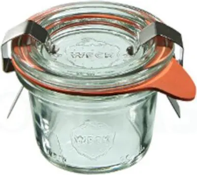 A close-up shot of a small glass jar with a lid and clips.