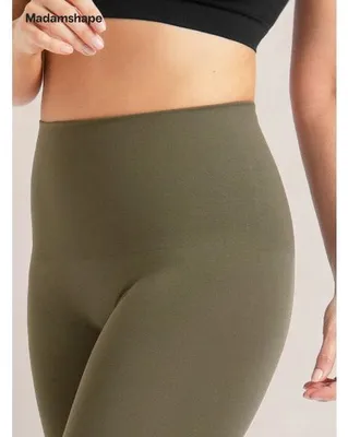 Olive green high-waisted leggings worn by a person, showing the smooth fabric and fit around the waist and hips