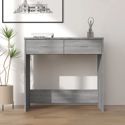 A gray wooden console table with two drawers is shown in a room with a plant and a framed picture on the wall.