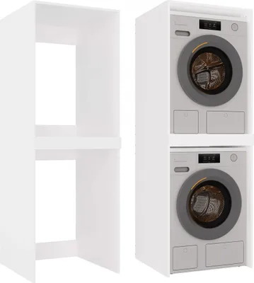 A white cabinet next to a stack of two washing machines.