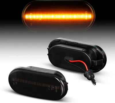 Two car side marker lights, one illuminated orange and the other dark.