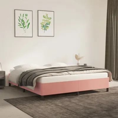 A bedroom scene featuring a pink bed frame with white bedding and a gray throw blanket.