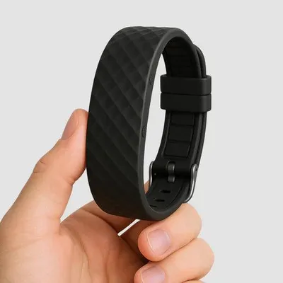 A hand holding a black smartwatch band.