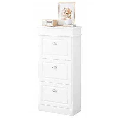A white shoe cabinet with three drawers is shown against a white background. Decorative items are placed on top of the cabinet.