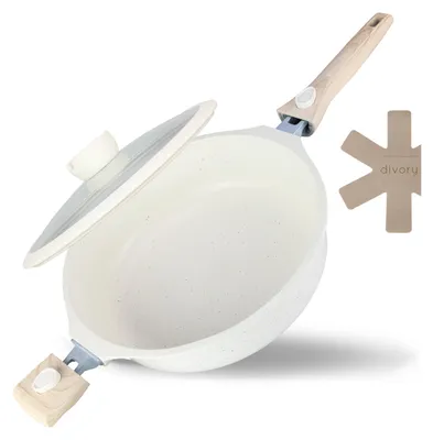 A white speckled frying pan with a glass lid and a wooden handle, shown at an angle on a white background. A beige trivet with the word 'divory' is visible to the right.