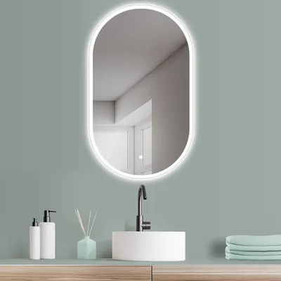 A modern bathroom vanity with a sink, faucet, and an oval LED mirror.