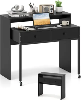 A black desk with a laptop, headphones, and a plant on it, with a smaller black unit in front.