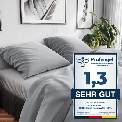 A bed with gray bedding and pillows, with a plant in the background and a product rating badge.
