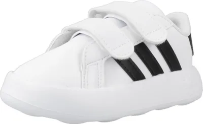 A white Adidas sneaker with black stripes and velcro straps.