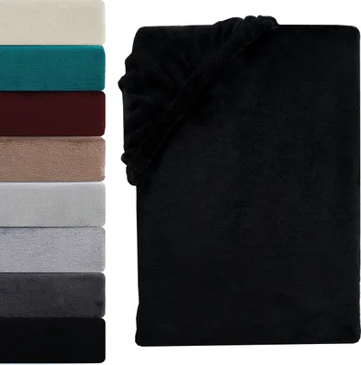 A stack of folded towels in various colors next to a black fitted sheet.