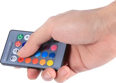 A hand holding a remote control for RGB LED lights.